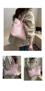 Dettaglio di borsa tote rosa con motivi floreali a rilievo e ricami a onde