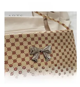 Detail of floral print underarm bag with silver bow buckle and grain leather texture