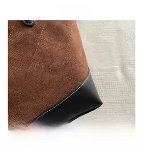Detail der braunen Wildledertasche mit Rautensteppung und schwarzem Lederboden