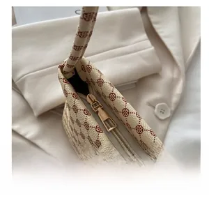 Detailed macro view of the smooth golden metal zipper and printed texture on the tote bag