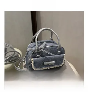 Détails d'un sac à main en denim gris avec bordure en dentelle, nœuds et anses argentées