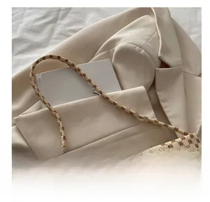 Detail of retro floral pattern bag with silver metal bow and thin shoulder strap
