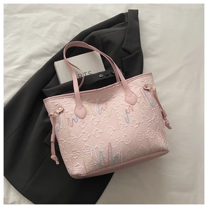 Dettaglio della borsa tote rosa con texture trapuntata e ricami colorati a onde