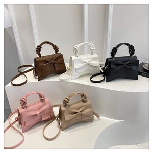 Detail of multi-color bow handbags on arc steps including brown, white, black and pink