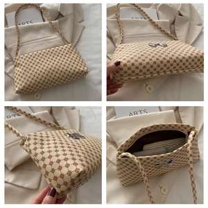Macro view of bowknot accent and red floral pattern on cream-colored shoulder bag