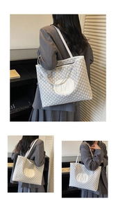 Detail of trendy tote bag with M-letter print and large circular logo on off-white leather