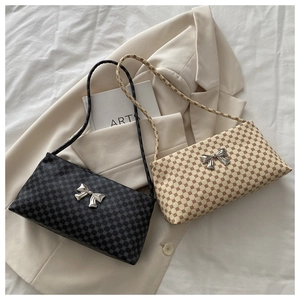 Detail of geometric pattern shoulder bags with silver bow buckle on beige blazer
