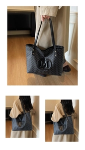Macro detail of monogram tote bag featuring embossed M logo and textured pattern