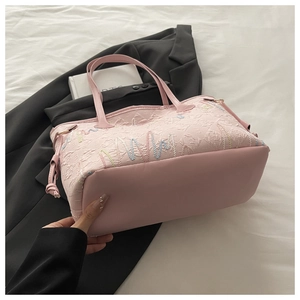 Dettaglio della borsa tote rosa con trama jacquard geometrica e base in ecopelle