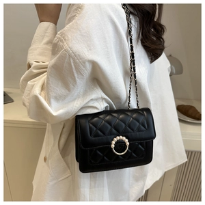Detail of quilted leather crossbody bag with pearl buckle and metal chain strap