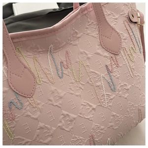 Dettaglio della borsa tote rosa con motivo E a rilievo e ricami ondulati multicolore