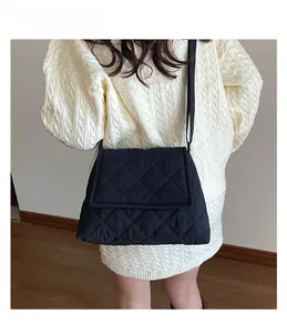 Detail of black quilted shoulder bag featuring rhombic stitching and soft fabric texture