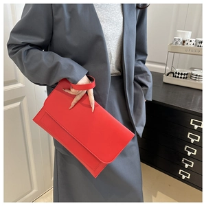 Urban chic red matte leather envelope clutch bag held by model in professional suit