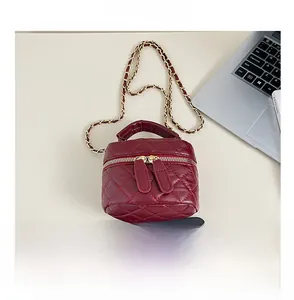Size comparison of a mini burgundy quilted chain bag next to a smartphone