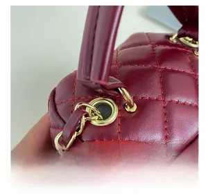 Macro shot of gold metal ring hardware and diamond quilted leather stitching details