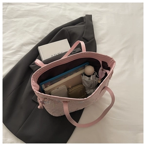 Interno della grande borsa tote rosa con laptop e oggetti essenziali quotidiani