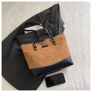 Detail of rhombic stitched tote bag featuring brown suede and black leather patchwork