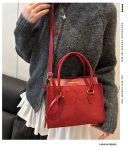 Macro detail of red crossbody bag showing suede and smooth leather textures