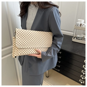 Urban square clutch bag with geometric print held by model in professional suit