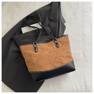 Detailed close-up of a quilted tote bag in brown suede and black leather on a blazer