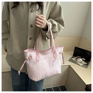 Dettaglio della borsa tote rosa con goffratura a F e cuciture ondulate su tessuto testurizzato