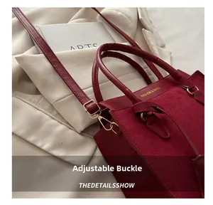 Detail of red leather and suede crossbody bag with adjustable gold buckle and strap