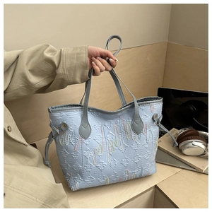 Dettaglio borsa tote trapuntata celeste con ricami colorati e coulisse laterale