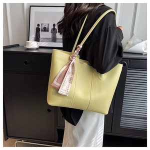 Detail of light yellow tote bag featuring a decorative pink plaid fashion silk scarf