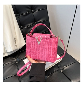 Borsa a secchiello magenta motivo coccodrillo con fibbia a V argento e manico superiore