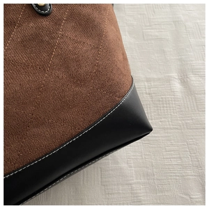 Detail der Rautensteppung aus braunem Wildleder und schwarzen Leder am Shopper
