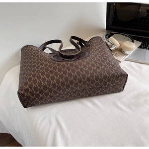 Macro view of vintage brown monogram tote bag with large capacity for daily commuting