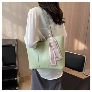 Lifestyle shot of large light green tote bag with decorative scarf on shoulder
