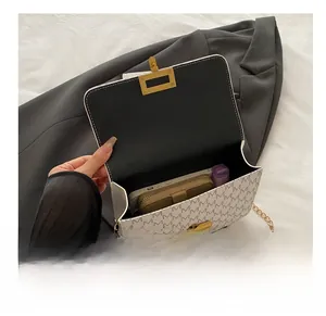 Internal view of a flap crossbody bag with M-pattern print showing ample storage space