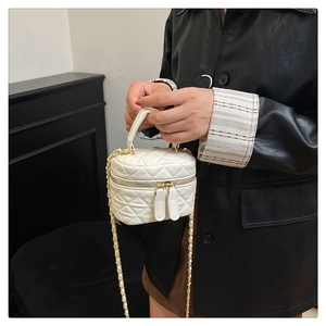 Detail of white quilted crossbody box bag with gold metal chain and round top handle