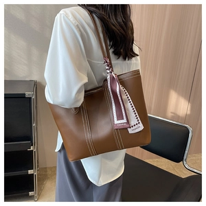 Detail of brown tote bag with white contrast stitching and fashion print silk scarf