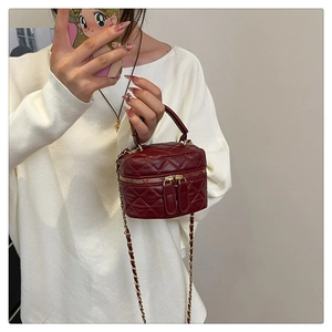 Detail of burgundy quilted chain crossbody bag shown in a fashion mirror selfie context
