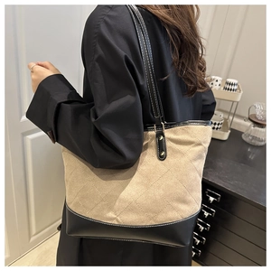 Detail of large tote bag showing quilted rhombus texture and contrast stitching details