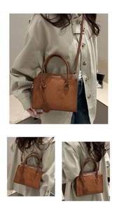 Detail of brown matte suede handbag with gold lettering and adjustable shoulder strap