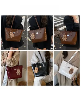 Detail view of large capacity glossy tote bags in multiple colors with bear charms