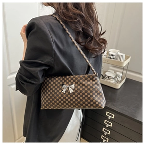 Detail of vintage brown baguette bag with silver bow buckle and dotted pattern