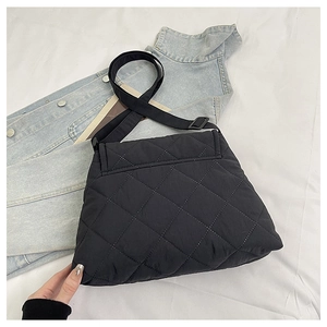 Close-up of black quilted rhombus stitching on a large capacity nylon crossbody bag