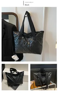Detail of black tote bag featuring butterfly embossing and quilted down fabric texture