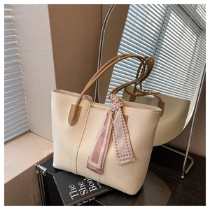 Detail of cream leather tote bag with brown straps and a pink geometric fashion scarf
