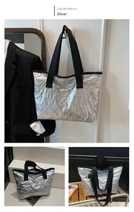 Detail of silver metallic tote bag with 3D bow quilting and wide black canvas strap