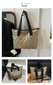 Detail of gold quilted tote bag with bow patterns and wide black fabric handle