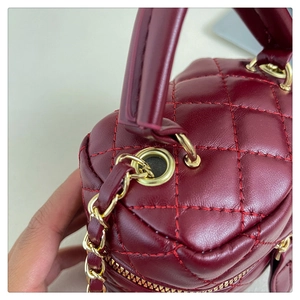 Macro detail of wine red quilted crossbody bag featuring golden chain and premium hardware