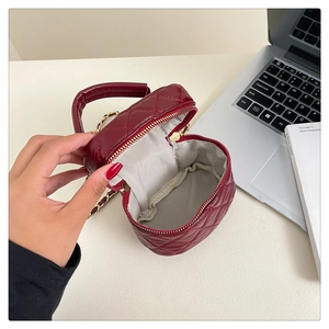 Interior detail of burgundy quilted mini chain bag showing storage and inner lining