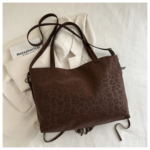 Detail of vintage leopard print tote bag featuring textured suede and stylish tassel fringe