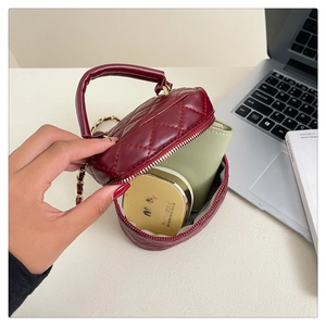 Internal capacity of burgundy quilted mini crossbody bag showing a compact wallet