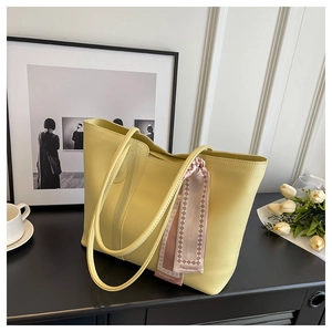 Detail of yellow tote bag with decorative fashion scarf and elegant tulip background